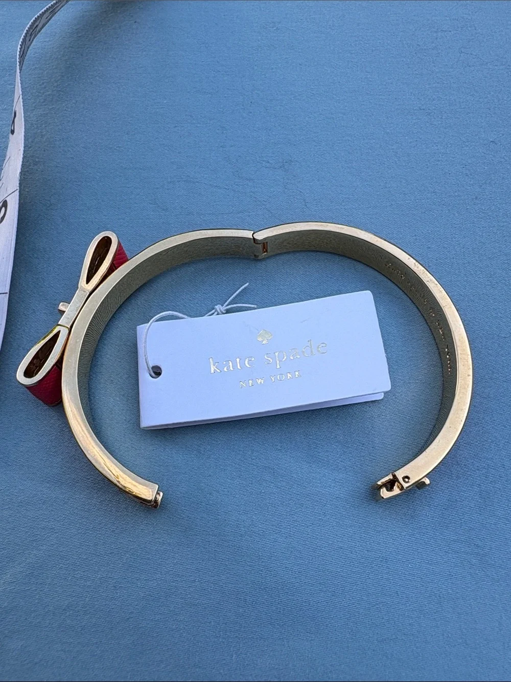 kate spade gold-tone bangle with pink enamel bow